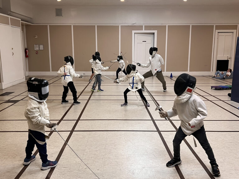Ethical Culture students in fencing gear practicing during an after school class