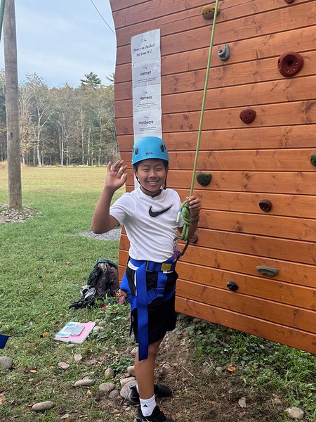 Ethical Culture student climbs rock wall on Ashokan outdoor learning trip.