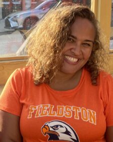 Patty Moreno-Fletcher smiles at the camera in a Fieldston t-shirt