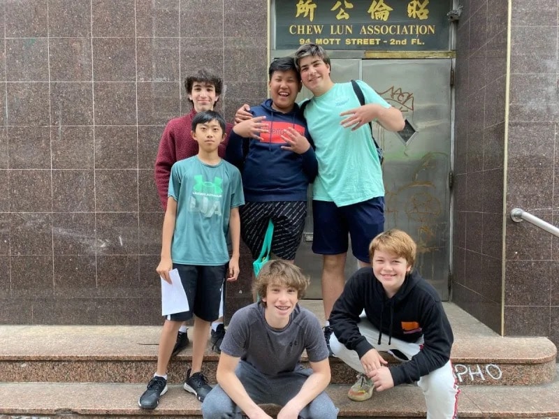 Group smiles together outside of a building in Manhattan