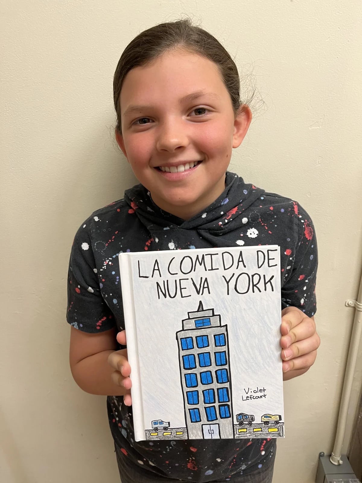 An Ethical Culture Fieldston School 5th Grade student holding a book they designed