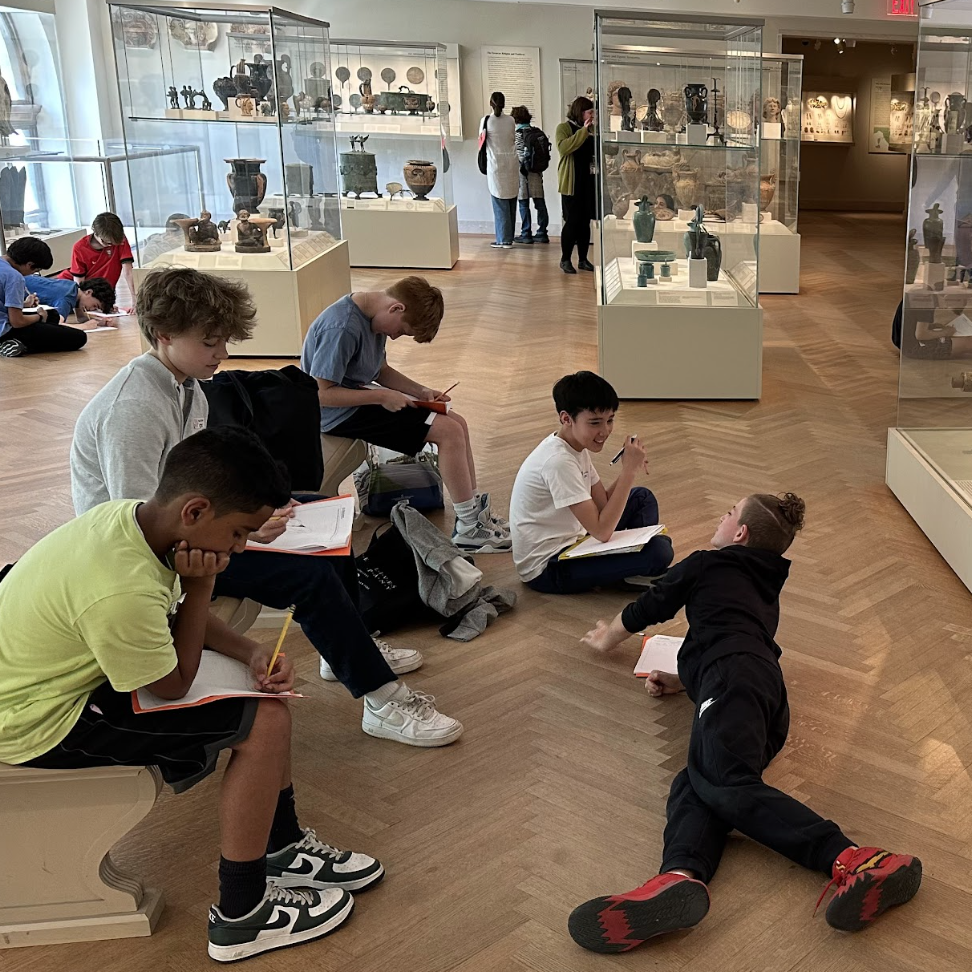 A group of ECFS Middle School students draw an artifact during an experiential learning trip to the Met