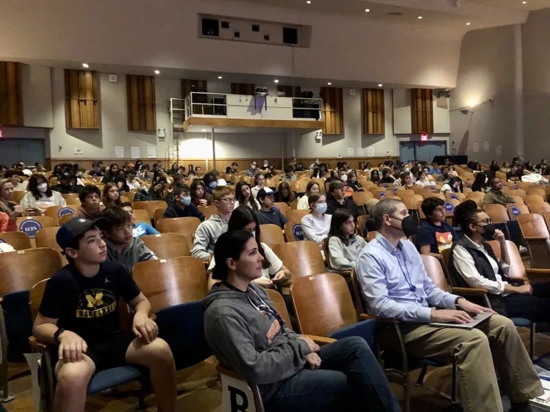 Students and faculty sit in auditorium and listen to guest speaker