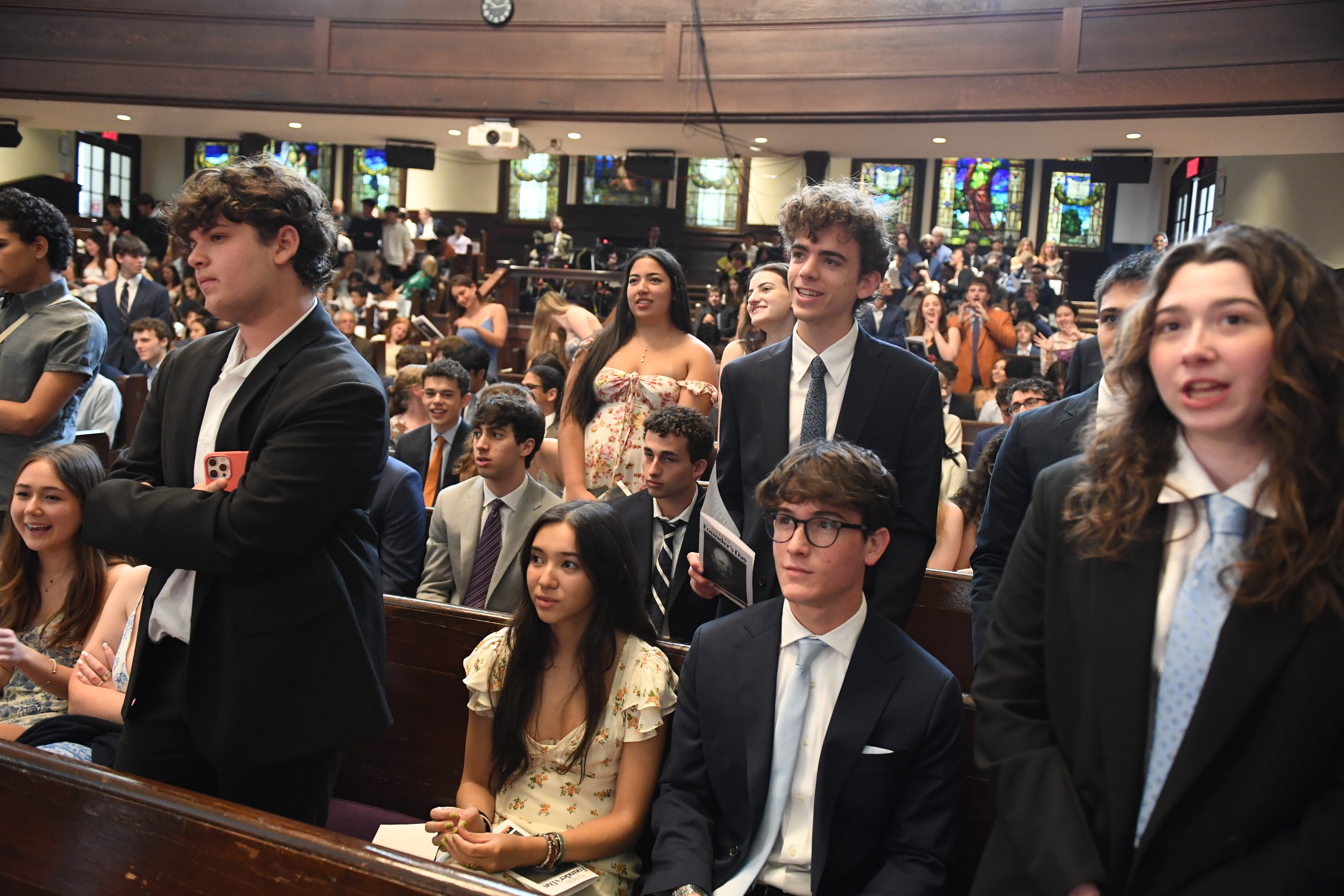 Students, some standing and some sitting, gathered in Adler Hall for Founder's Day