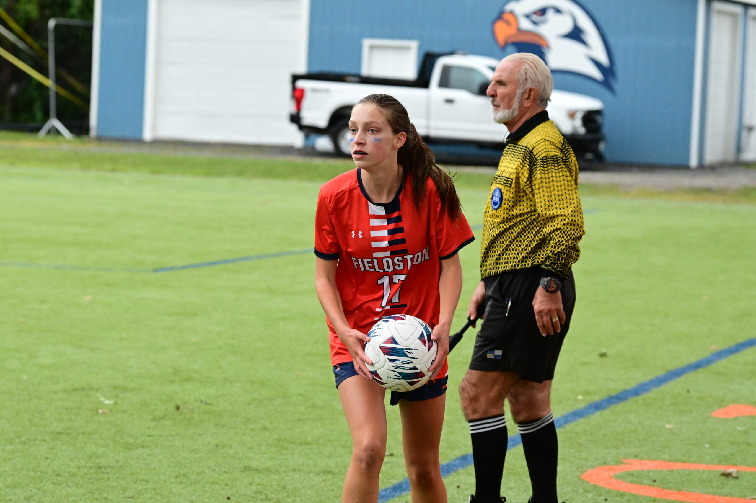 A player on the girls soccer team gets ready to throw the ball back onto the field from the sidelines