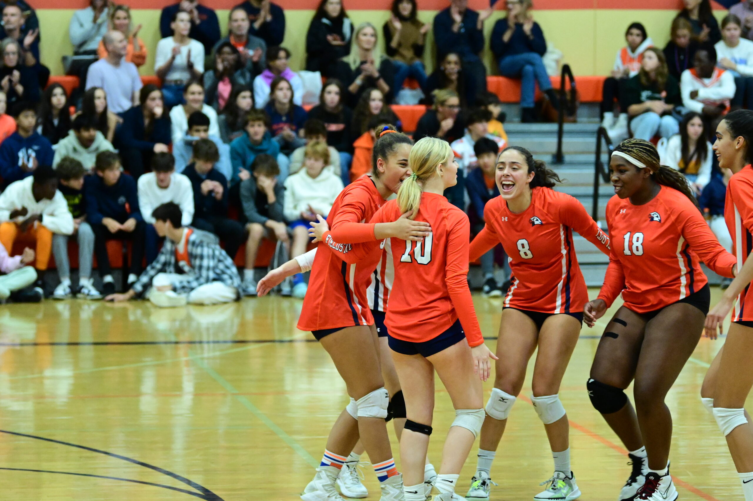 Volleyball players celebrate a point at Homecoming