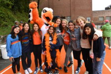 A group of students pose with the Eagle next to the upper field