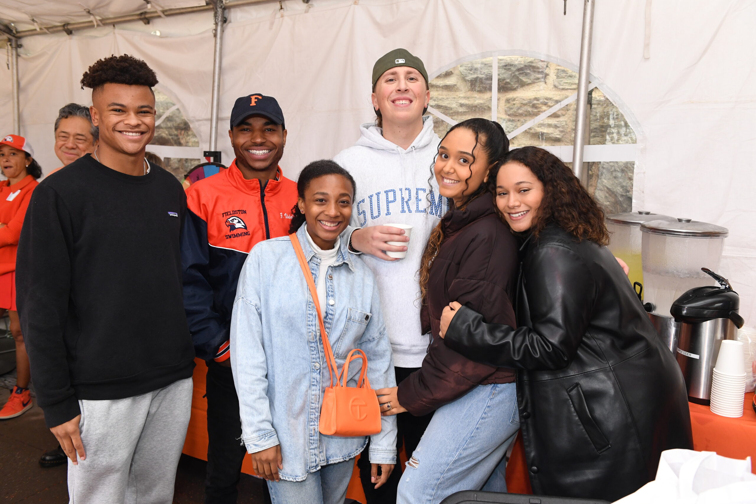 Community members pose in the ECFS alumni tent at Homecoming