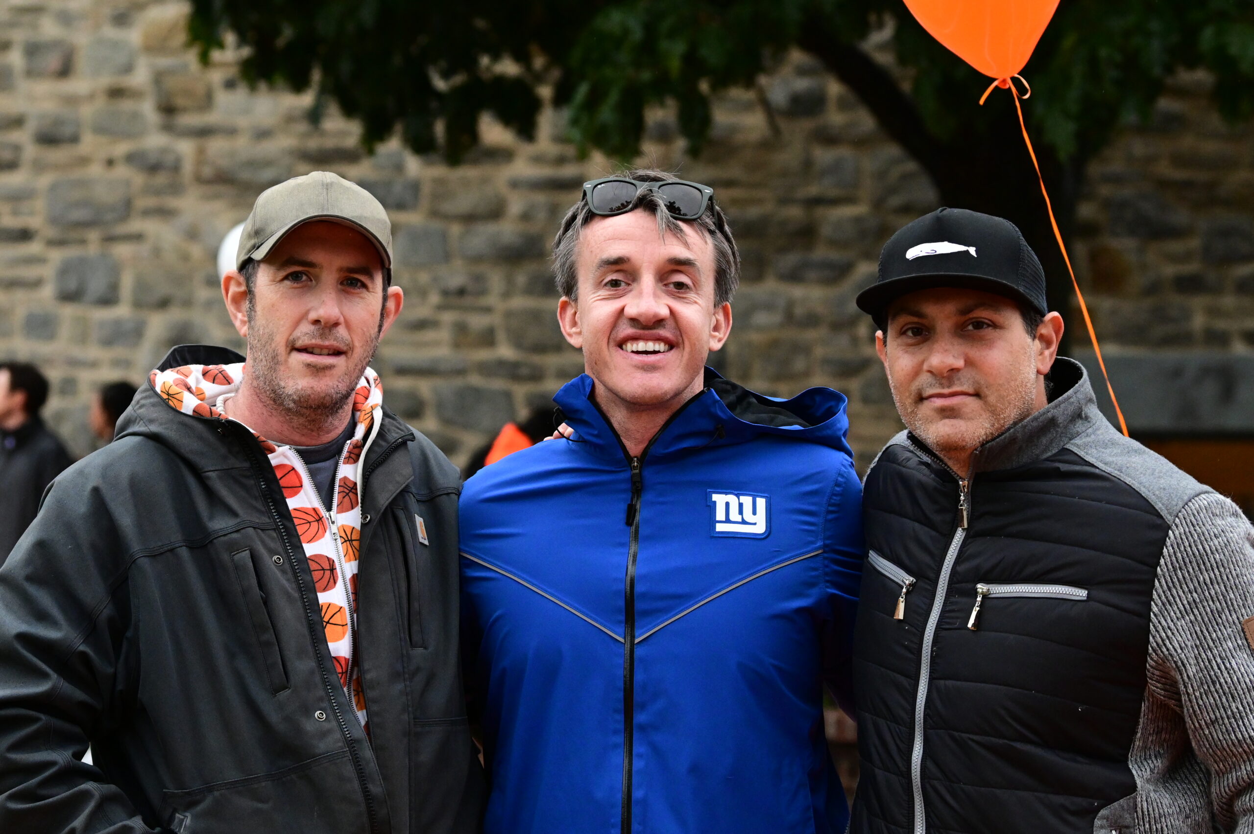 Three alumni pose at Homecoming