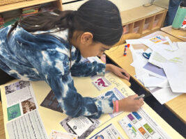 Ethical Culture student works on her poster about the Equal Rights Amendment in classroom.