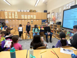 Women's Rights Social Justice Action Group gathers in classroom to discuss upcoming initiatives; they sit in chairs in a circle.