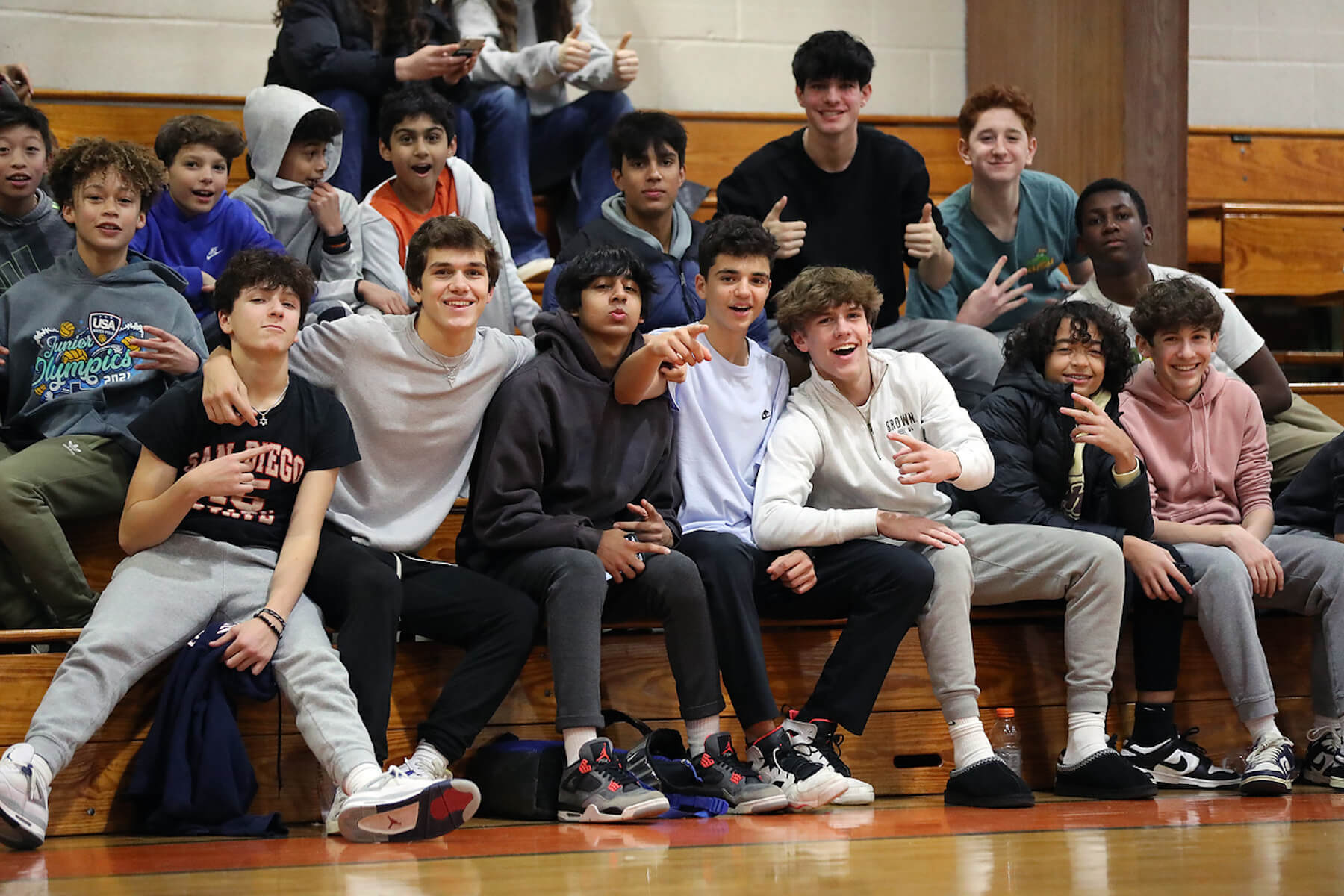 ECFS students cheer on basketball teams from the bleachers and smile at the camera.