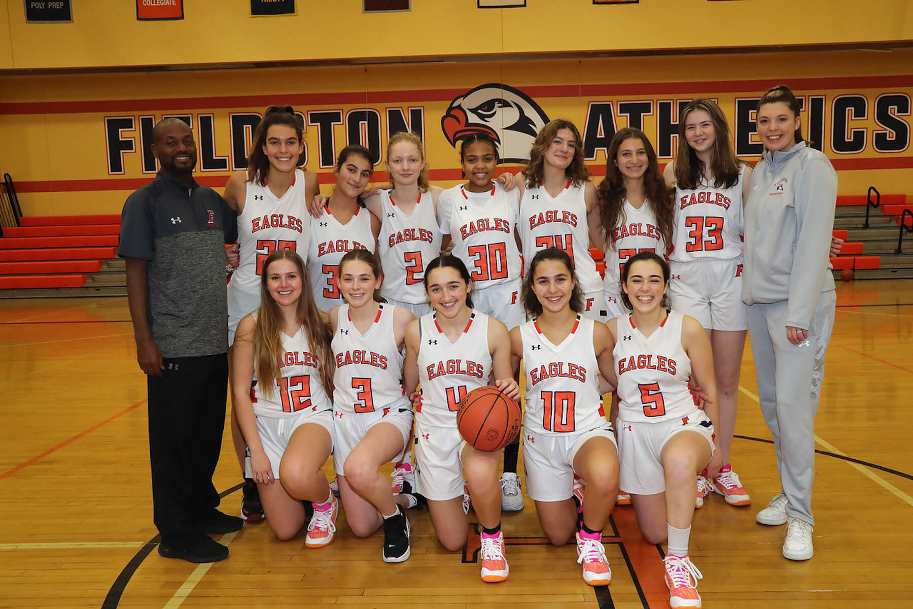 Fieldston Upper girls varsity basketball poses for group photo in varsity gym.