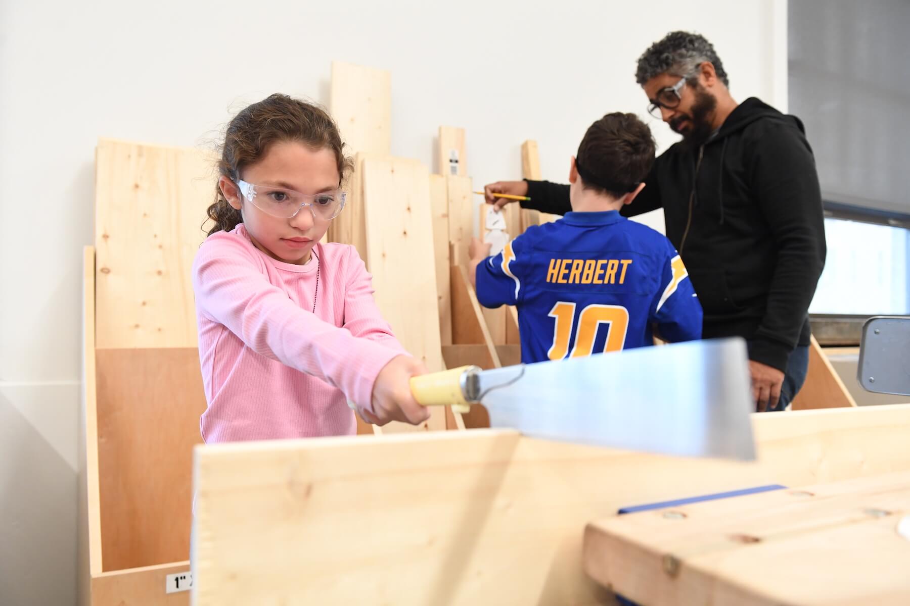 Ethical Culture Fieldston School Lower School student uses a saw in the wood shop