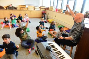 Ethical Culture Fieldston School Lower School students raise hands in music class