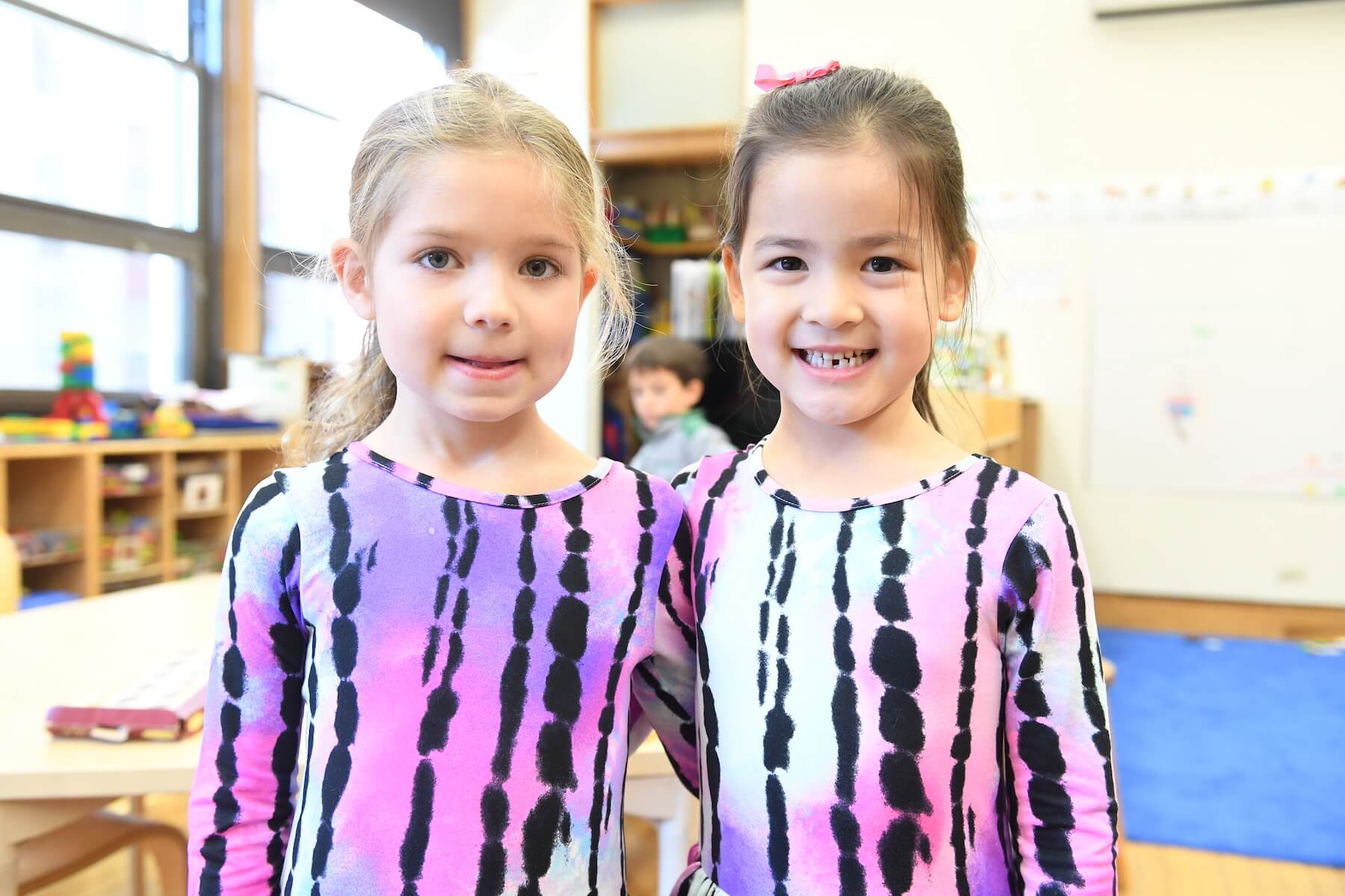 Ethical Culture Fieldston School students in matching shirts smile at the camera