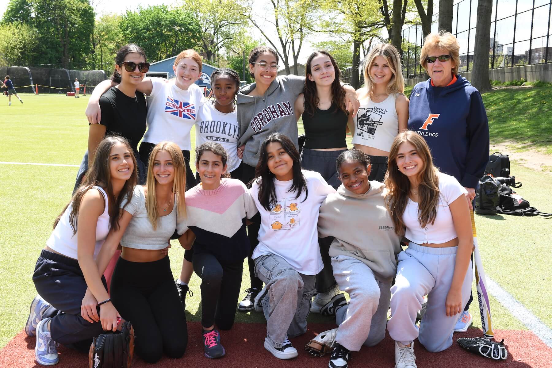 Group of Ethical Culture Fieldston School Middle School students smiling at camera on field