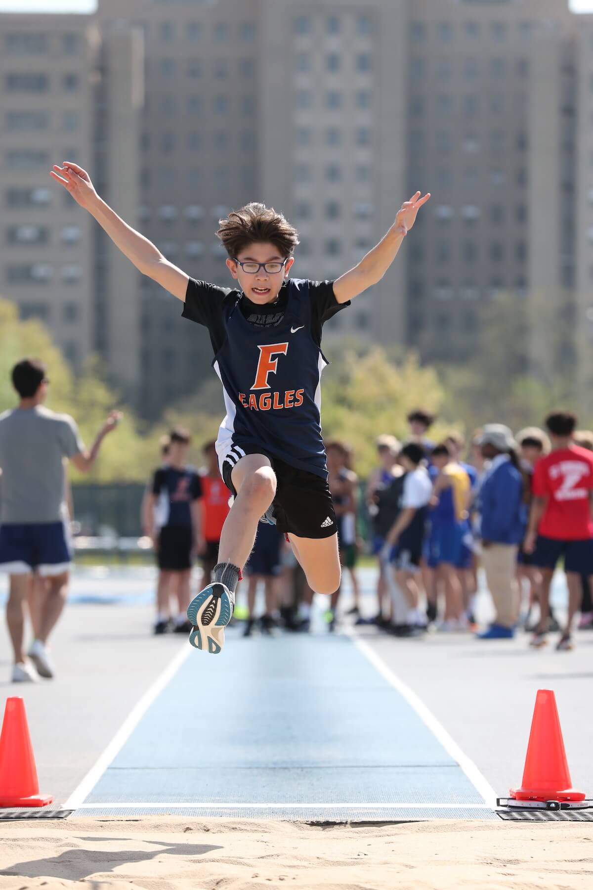 Ethical Culture Fieldston School Middle School track and field student is captured mid-air during a long jump