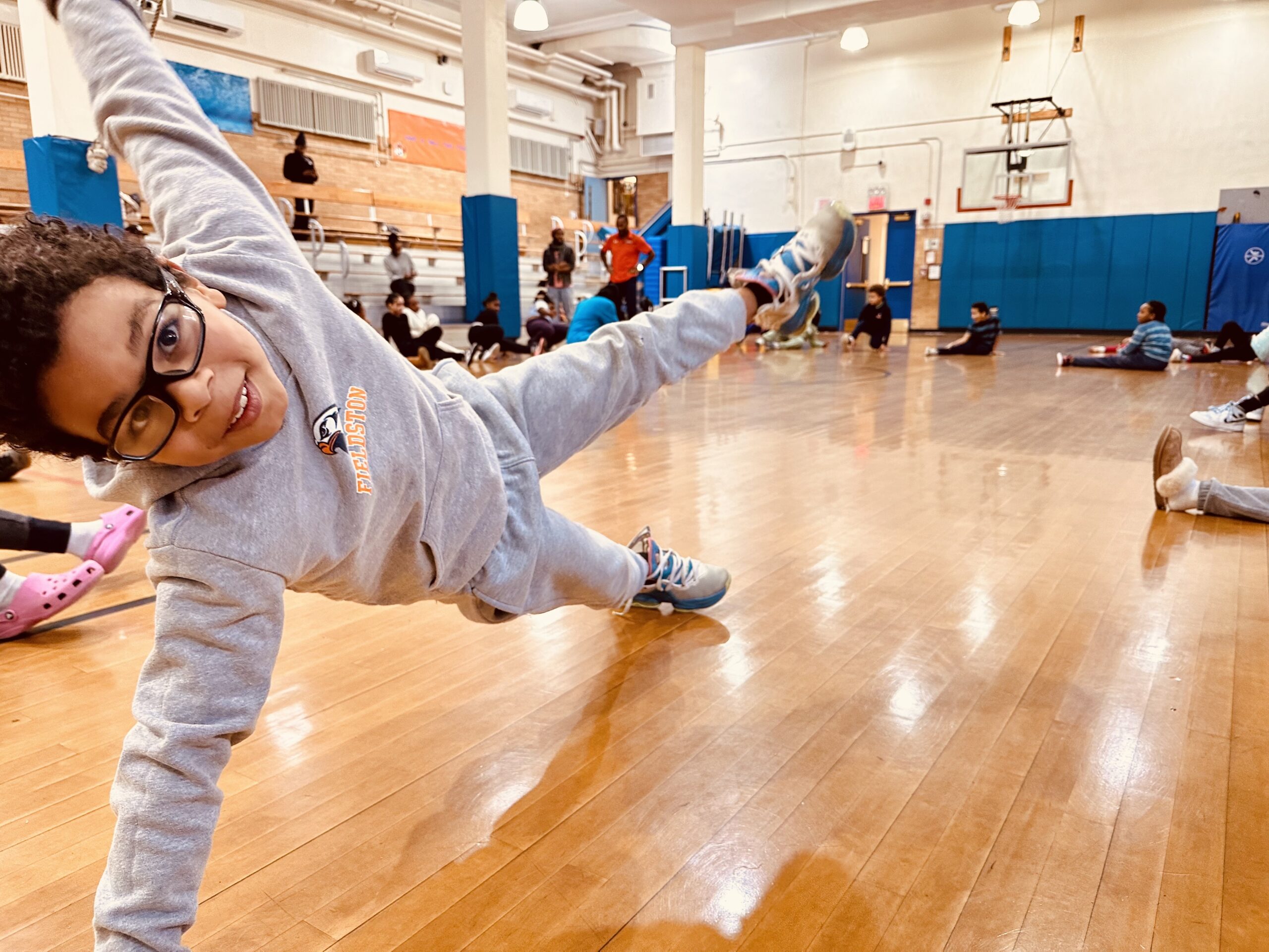 Fieldston Lower student practices breakdancing in gym.