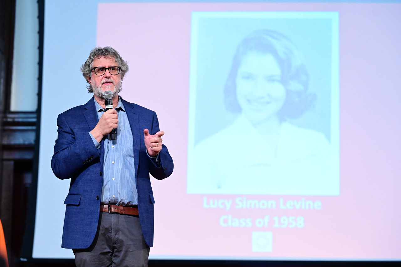 Head of School Joe Algrant gives speech on stage about Lucy Simon Levine's ’58 legacy at Ethical Culture Fieldston School.