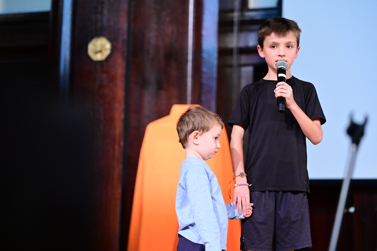 Ethical Culture's youngest and oldest current students stand on stage to honor Lucy Simon Levine with a speech.