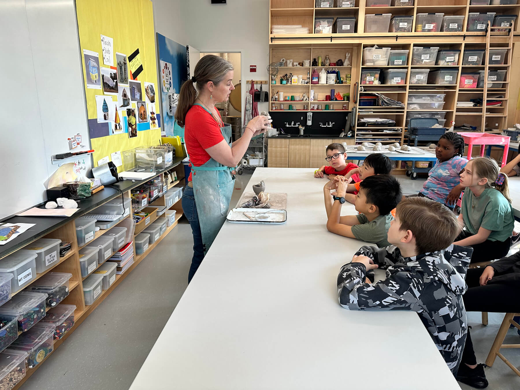 Art teacher Kate Eady demonstrates technique to 2nd Grade students.
