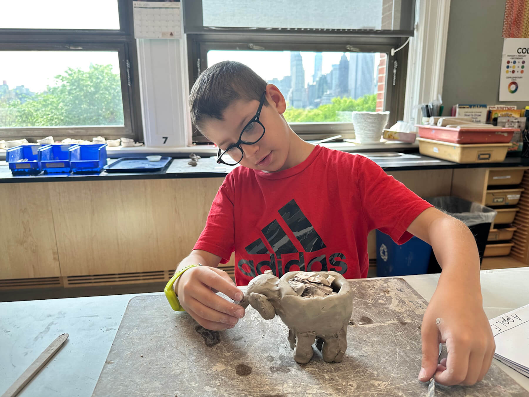 Ethical Culture student observes his clay creation in the art classroom.