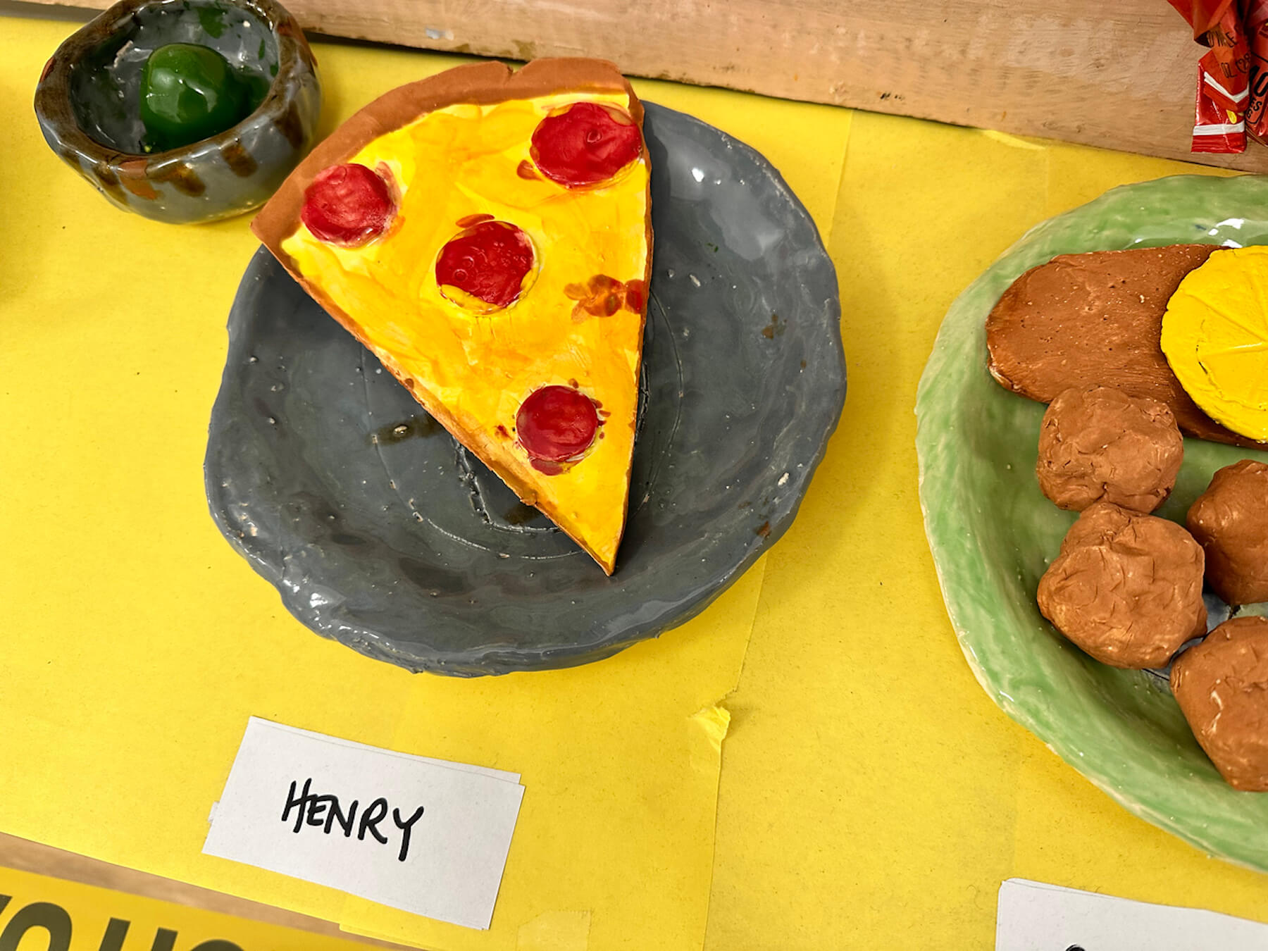 Ethical Culture 4th Grade ceramics projects (food sculptures) sit on display in hallway outside of art classroom.