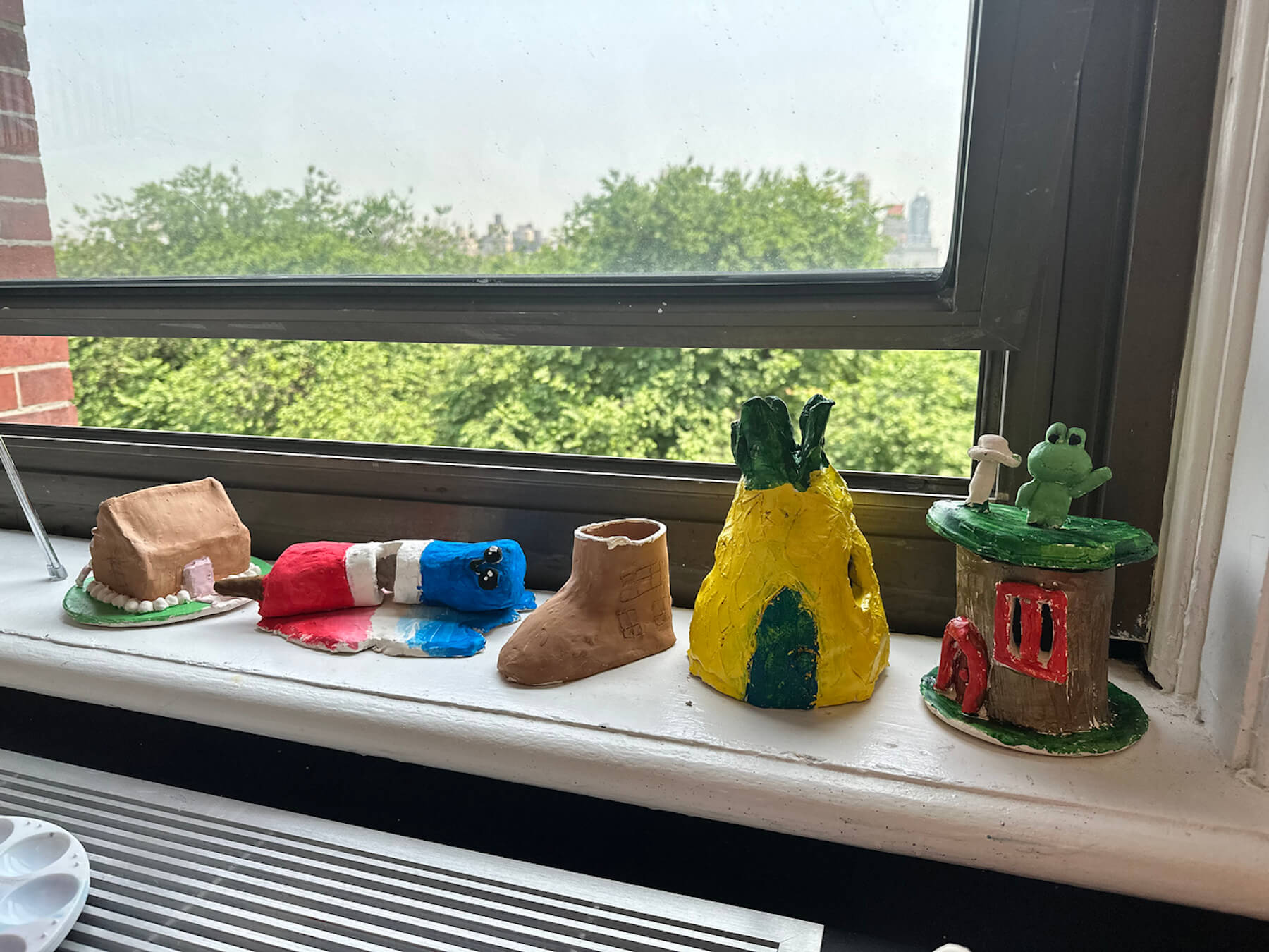 Student creations dry on windowsill in Ethical Culture art room.