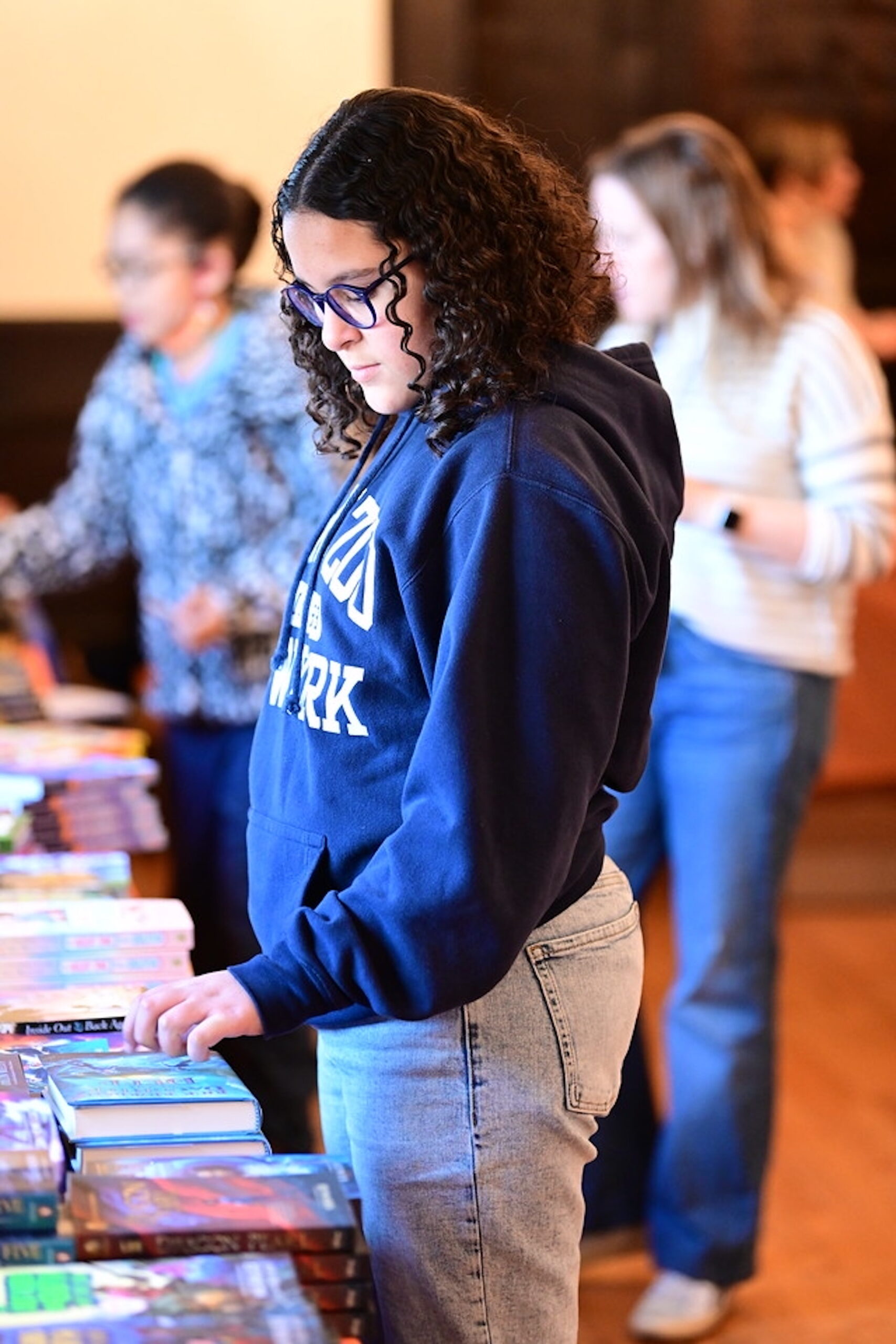 Student browses for books at the Ethical Culture Book Fair.