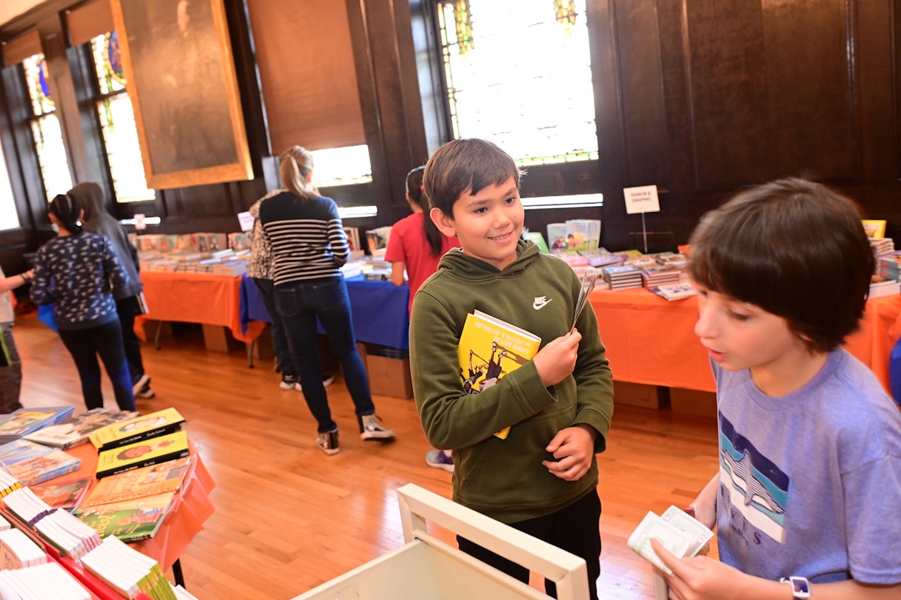 Ethical Culture students smile as they browse for books at the Book Fair.