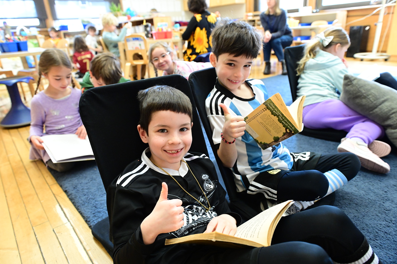 ethical culture fieldston school ethical culture students read together in groups on carpet in classroom.
