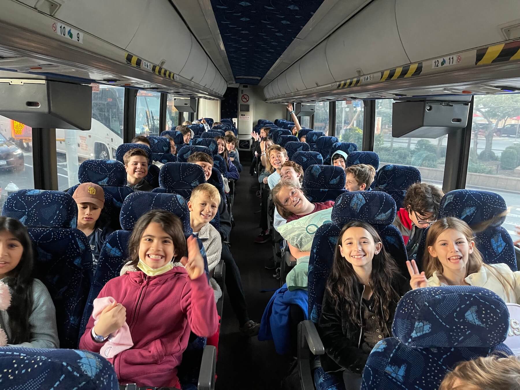 Ethical Culture's 5th Graders smile on bus on the way to Nature's Classroom!