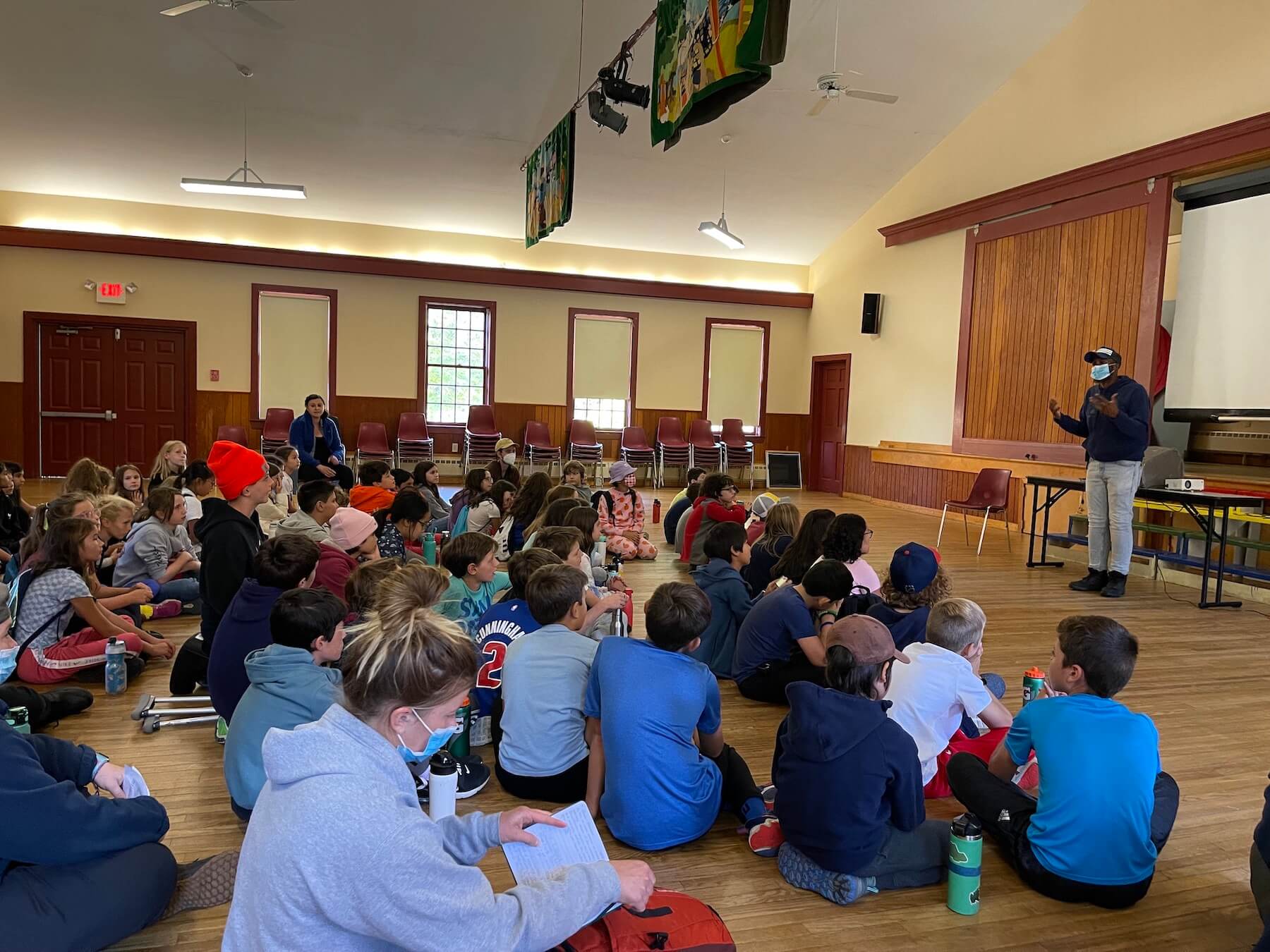 Students sit gathered on the floor as a counselor from Nature's Classroom instructs the group.