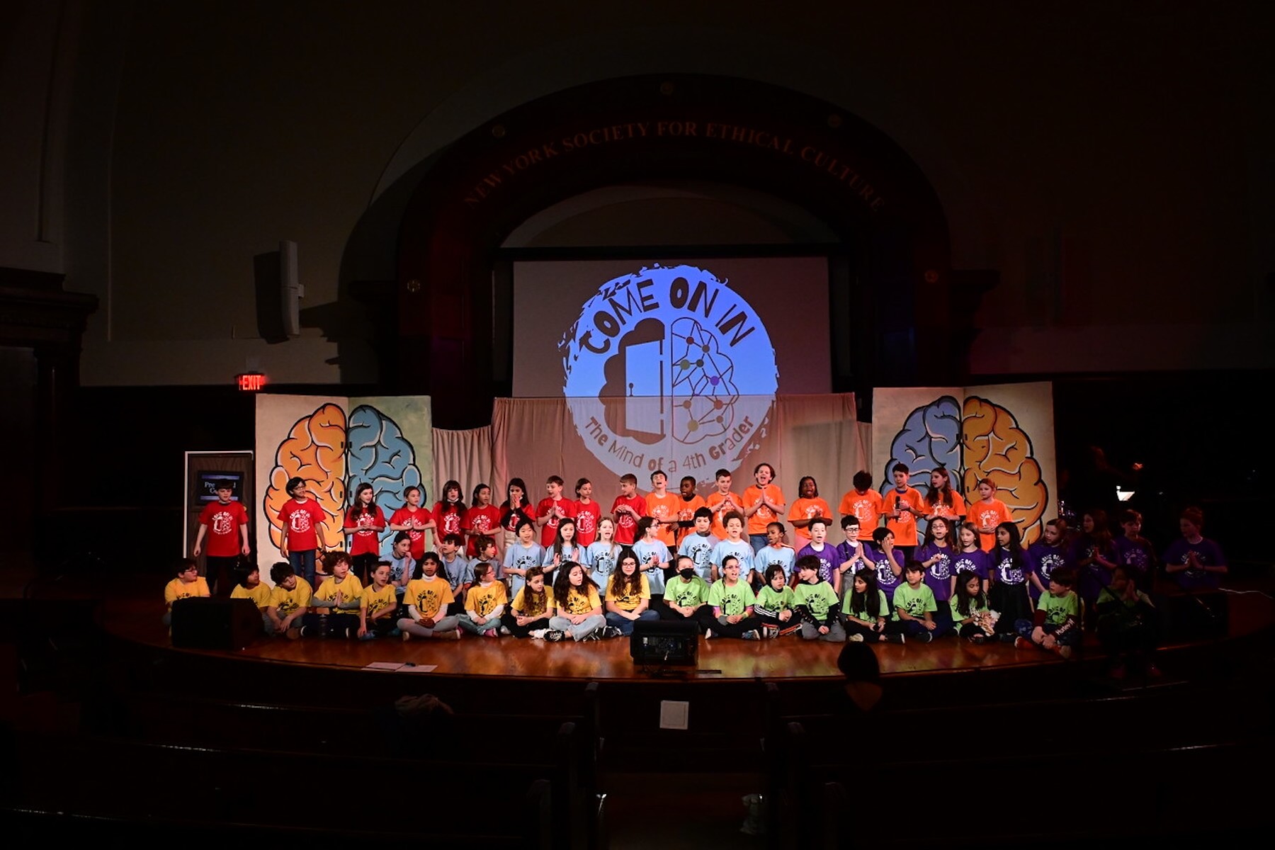 Entire cast of Ethical Culture 4th Grade play poses on stage during performance.