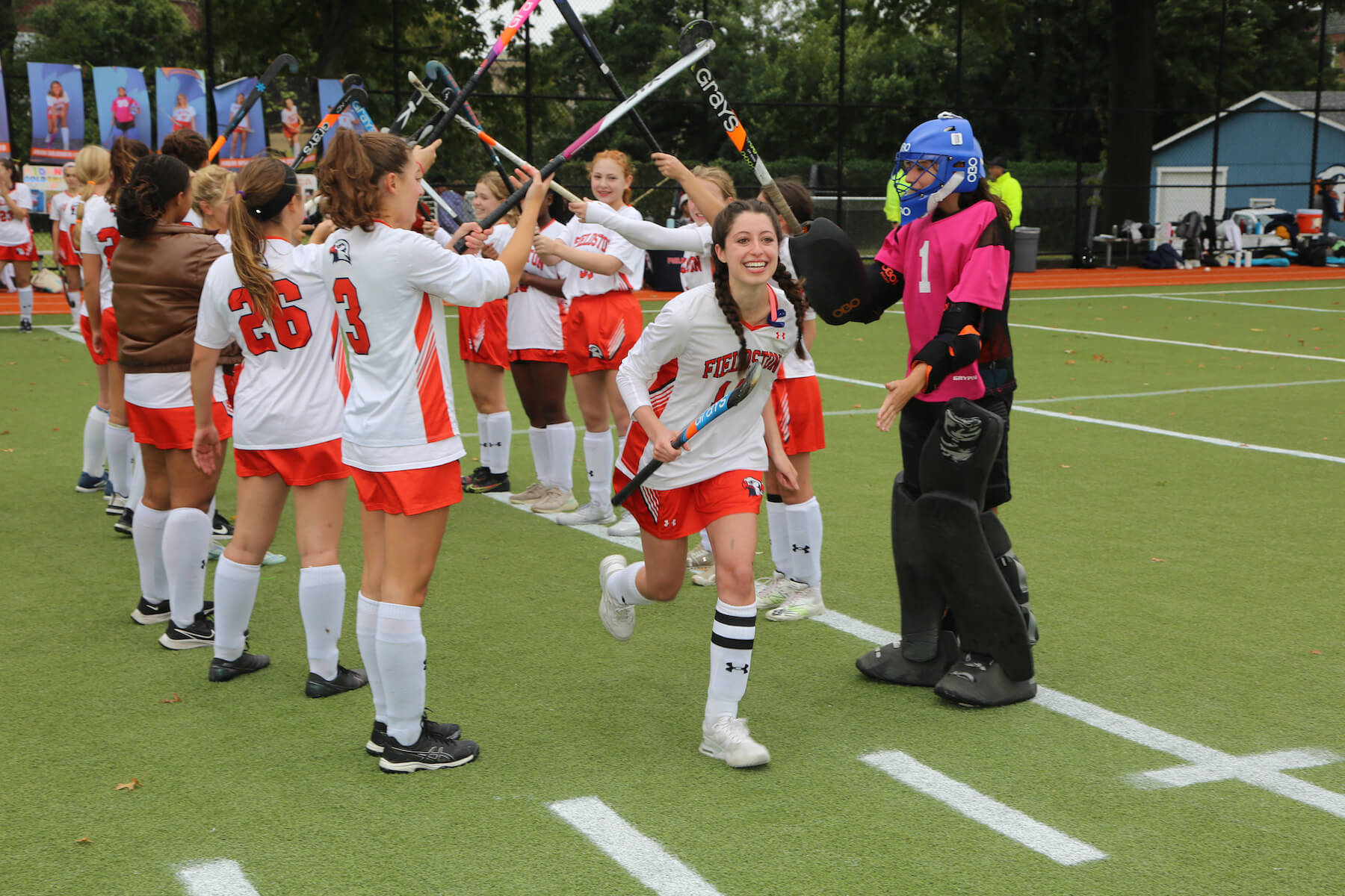 Ethical Culture Fieldston School Fieldston Upper student runs through arch of hockey stick