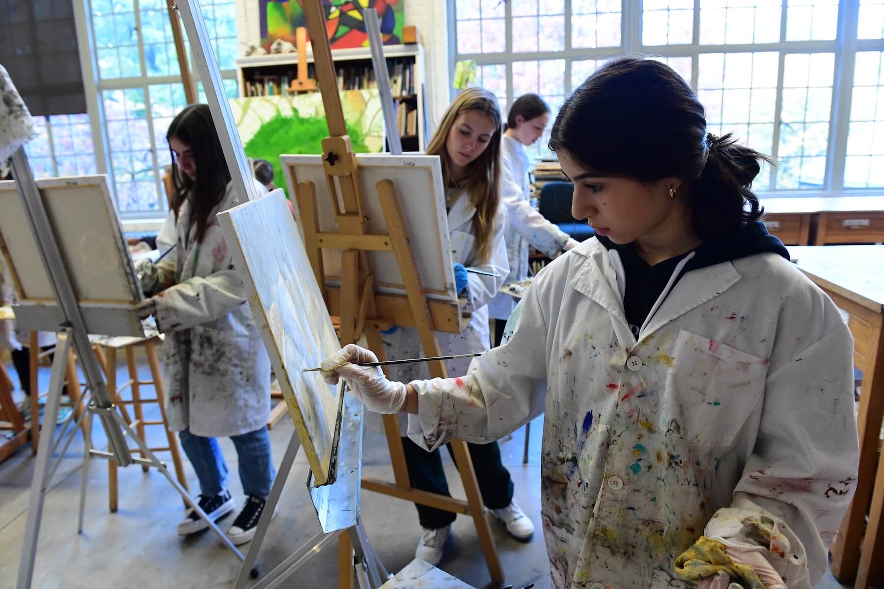 Ethical Culture Fieldston School Fieldston Upper students painting on easels in art class