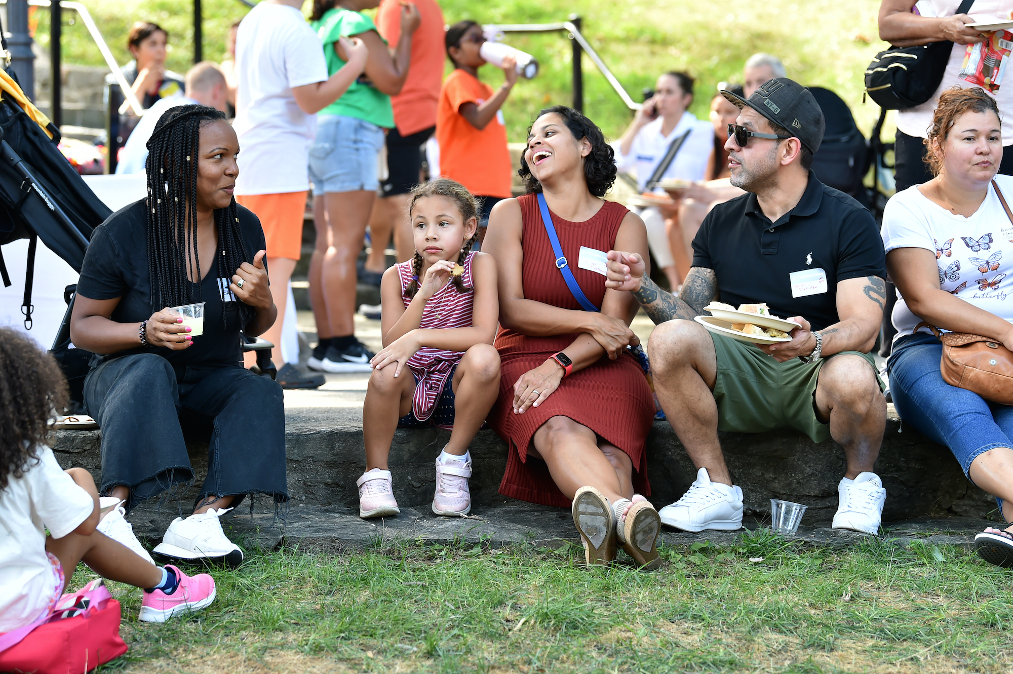 Families smile and talk as they sit on the quad at the back to school celebration