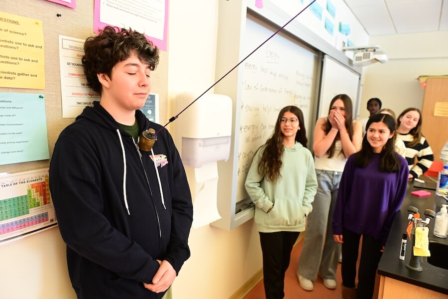 Ethical Culture Fieldston School Middle School students experiment with a pendulum in science class