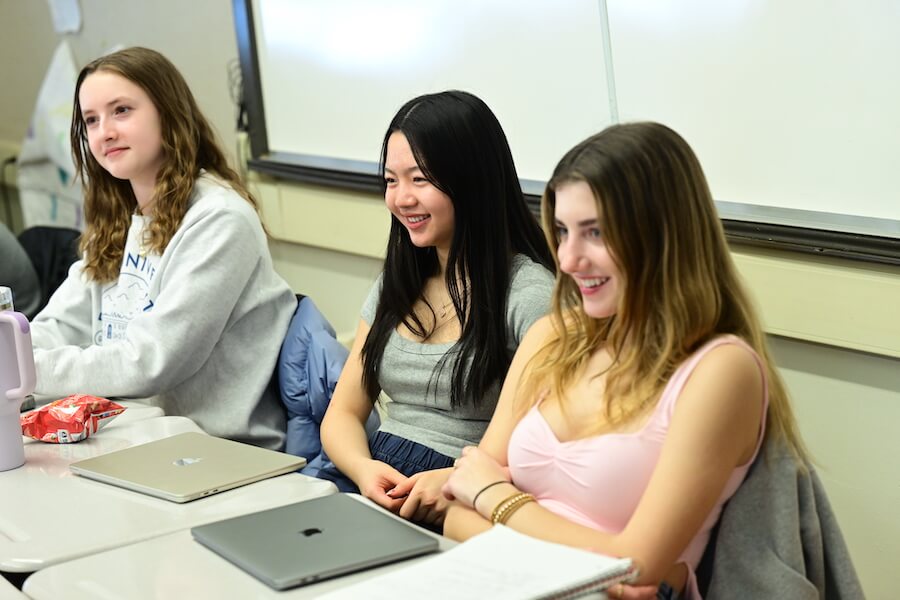 Ethical Culture Fieldston School Upper School students sit in class smiling