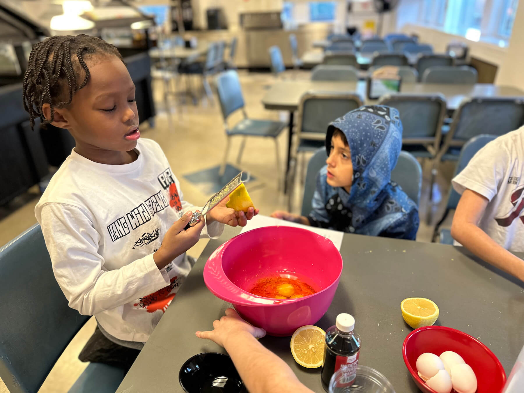 Ethical Culture Fieldston School students zesting a lemon in after school cooking class