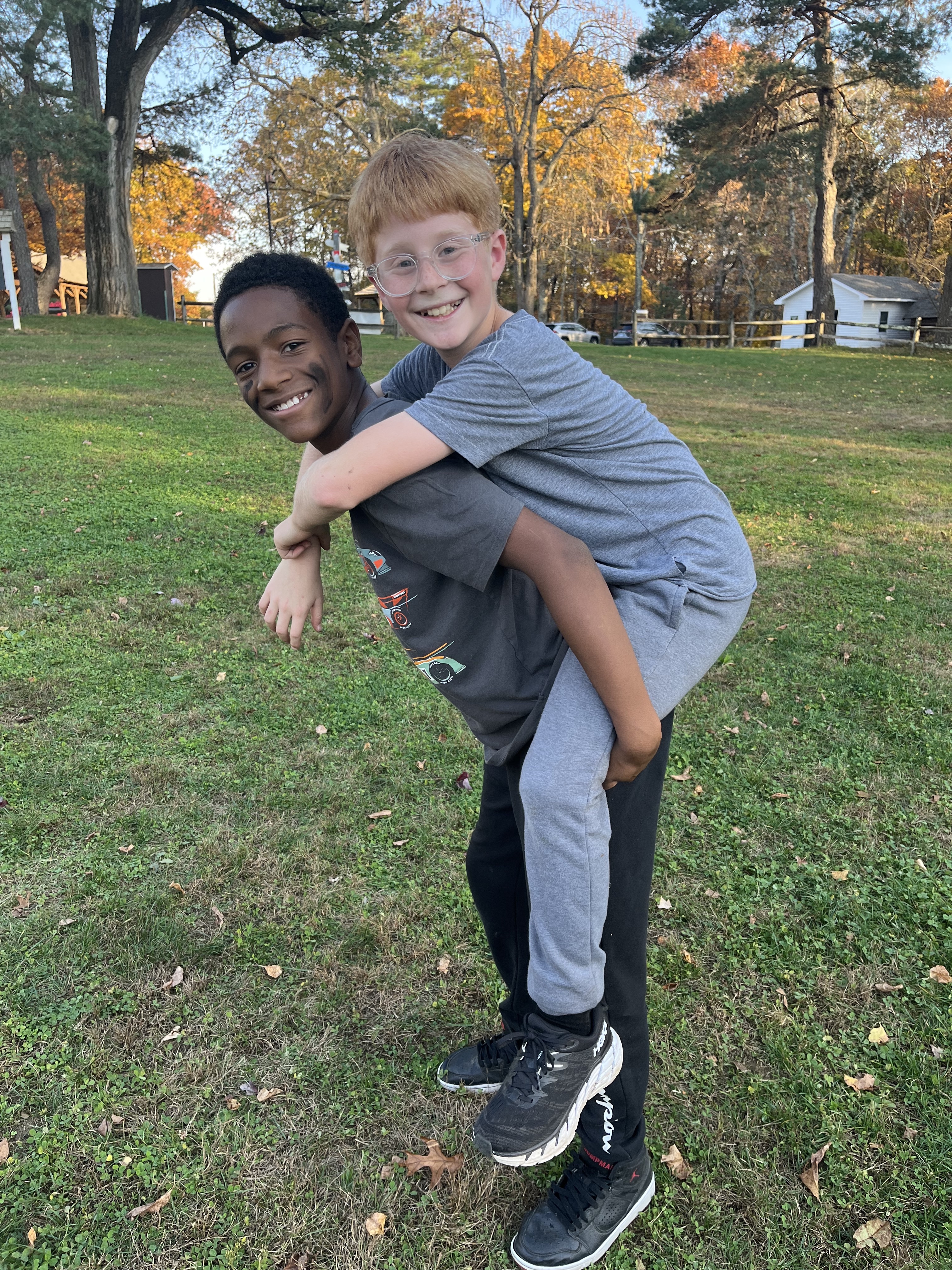Students give each other piggy back rides outside.
