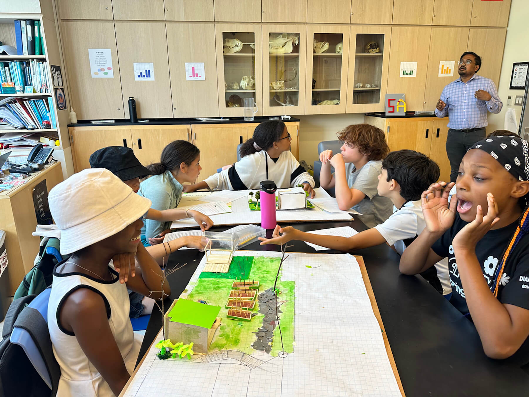 Fieldston Lower students sit at desks with their Shark Tank model classroom waiting to present.