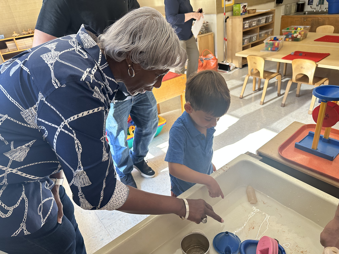 Fieldston Lower teacher points out something in the sandbox to a Pre-K student in a classroom.