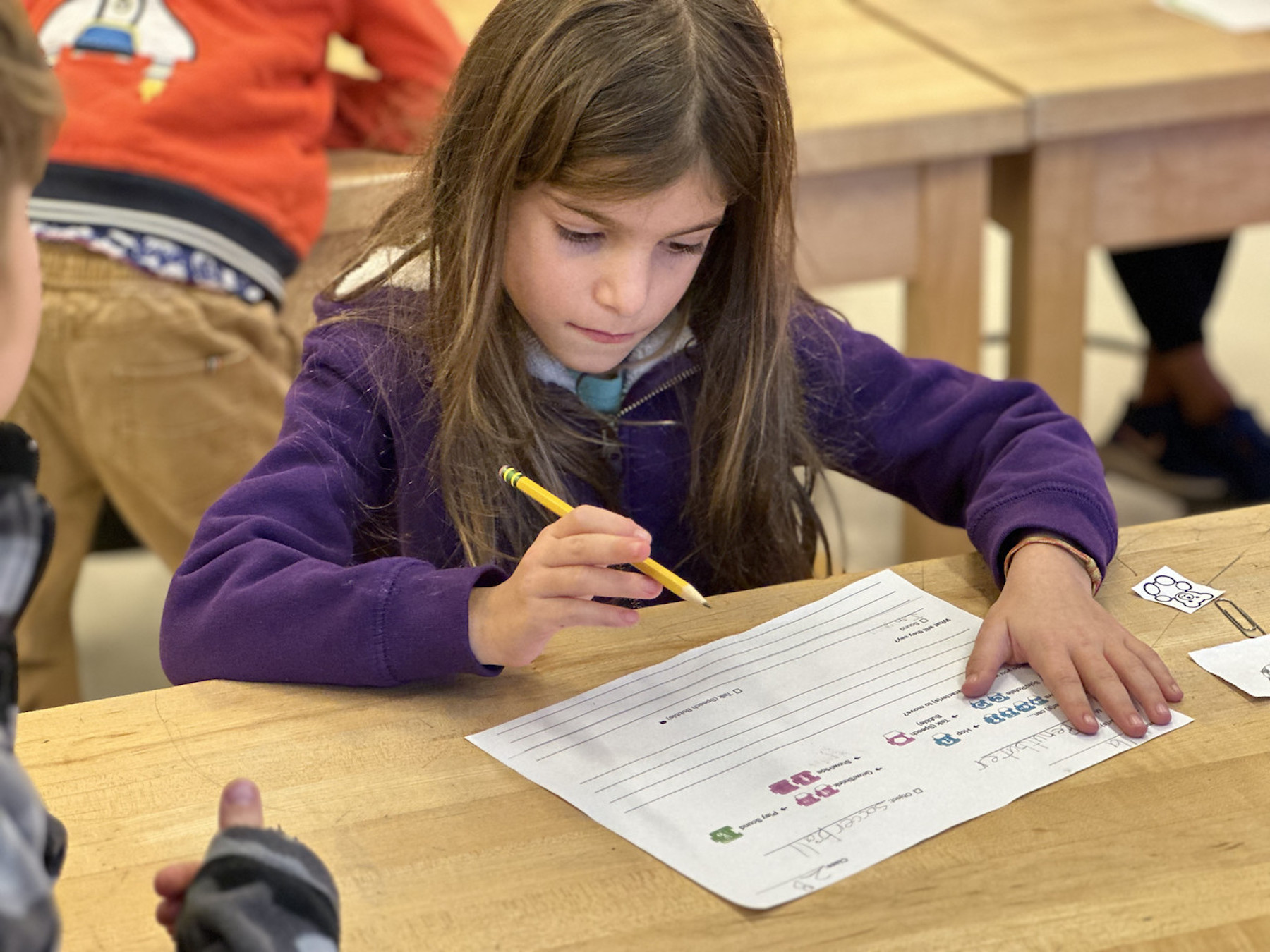 Fieldston Lower student works on her storyboard at desk in classroom.