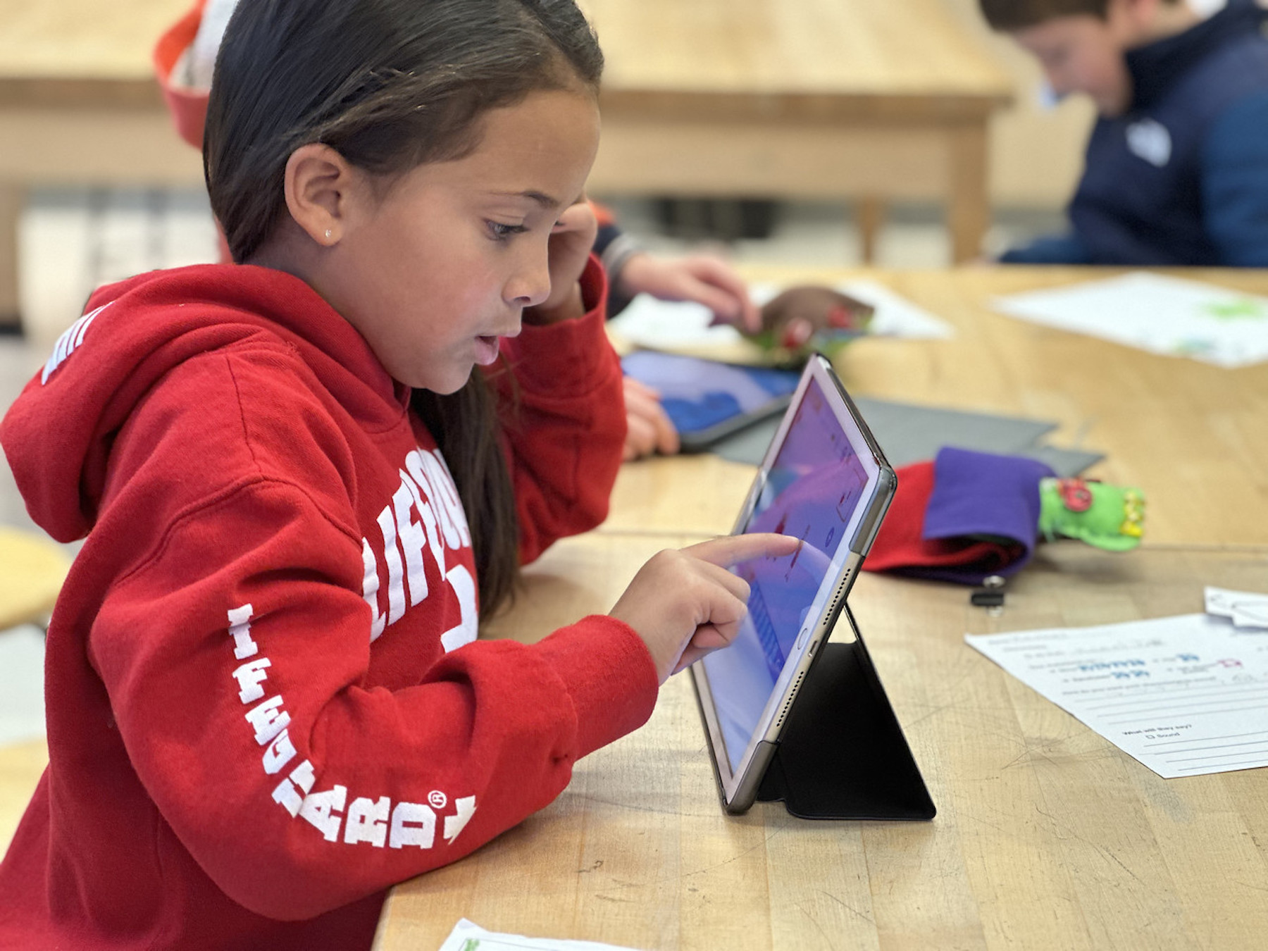 Fieldston Lower student works on iPad while sitting at desk.