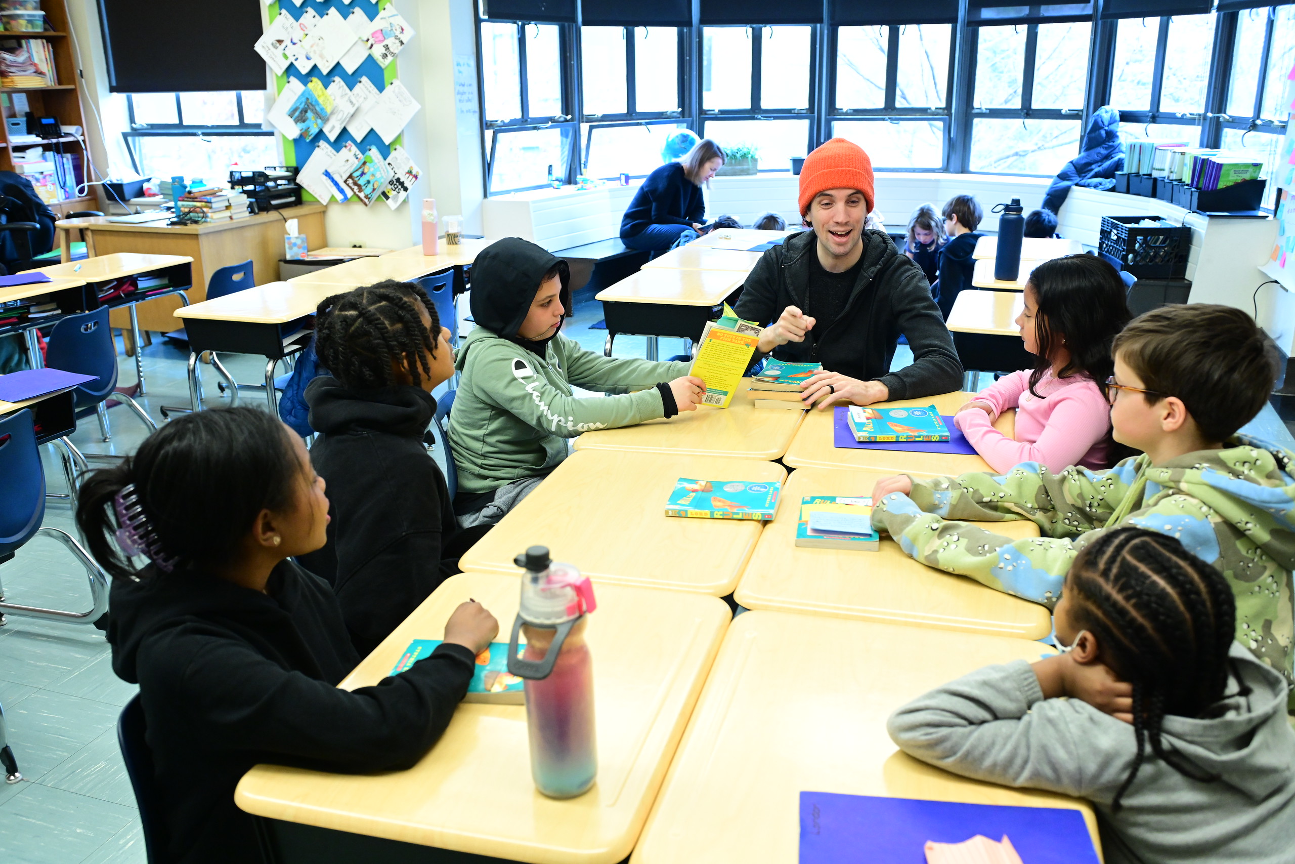 Fieldston Lower students listen and sit at desks as teacher leads discussion about a text.