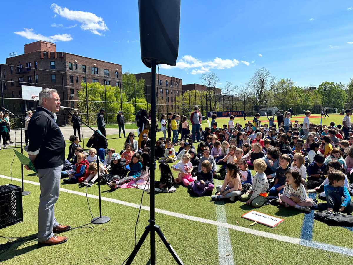 Fieldston Lower Principal Joe McCauley opens the Earth Day assembly outdoors on the lower field as students look on.
