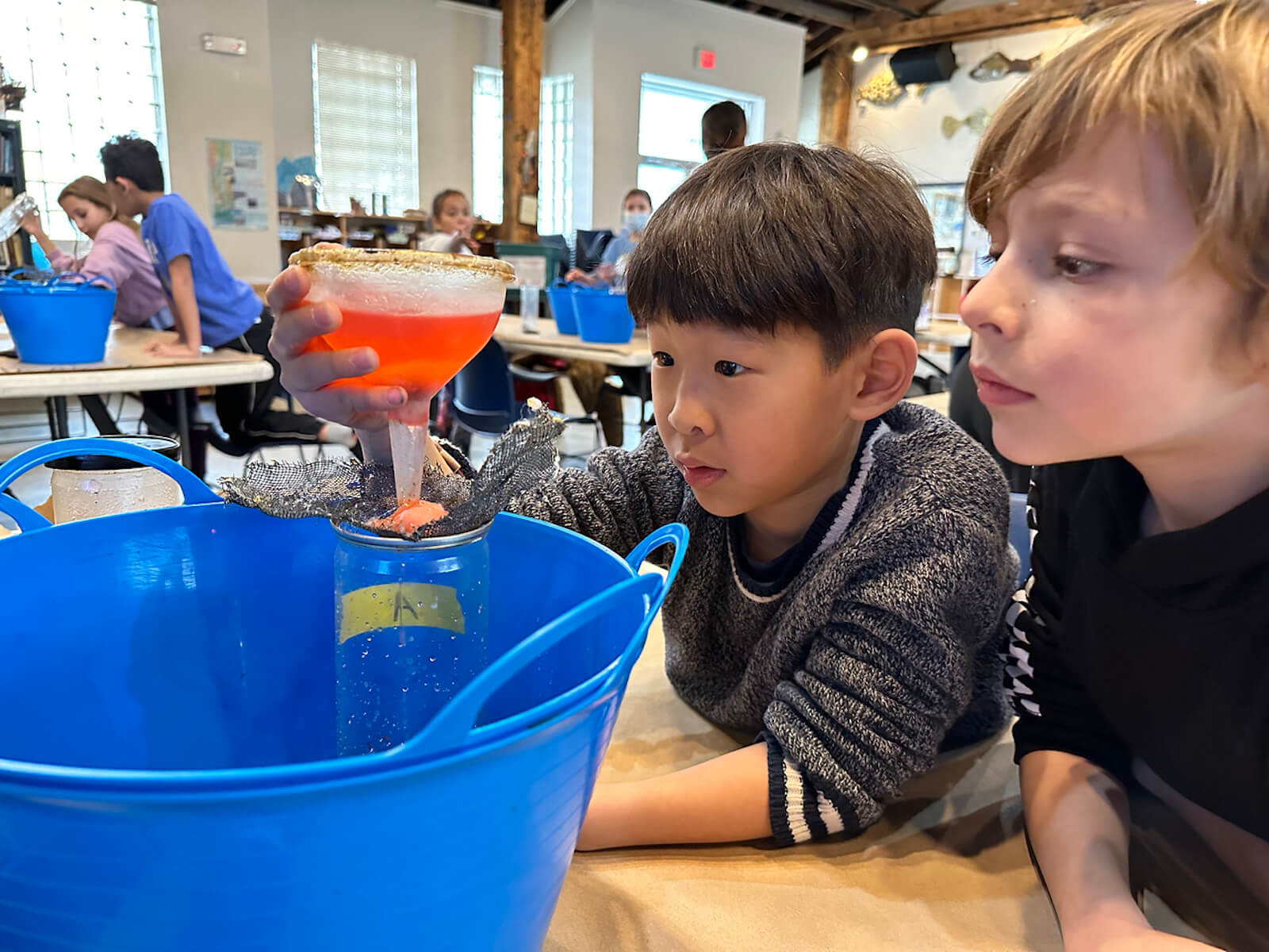 Fieldston Lower students clean water using a filter at the Beczak Center.