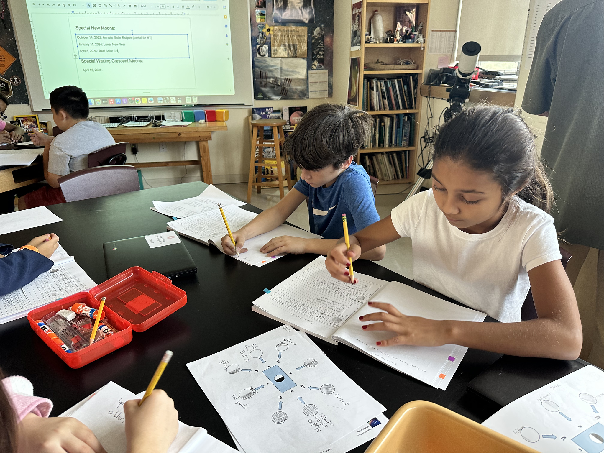 Students sit at desks and work on moon lab in Fieldston Lower classroom.